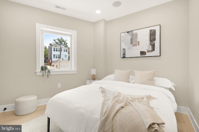 bedroom with wood finished floors, recessed lighting, baseboards, and visible vents