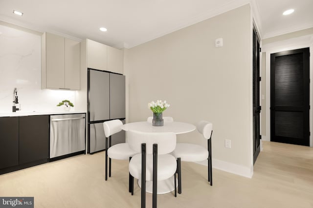 dining area with recessed lighting, light wood-type flooring, crown molding, and baseboards