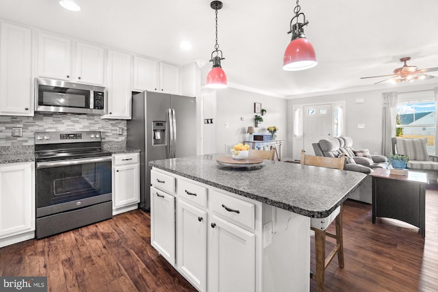 kitchen featuring ornamental molding, dark wood-style floors, open floor plan, stainless steel appliances, and decorative backsplash