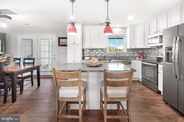 kitchen with stainless steel appliances, tasteful backsplash, dark wood-style flooring, and white cabinetry