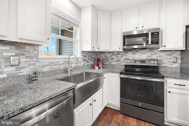 kitchen with a sink, white cabinets, backsplash, and stainless steel appliances