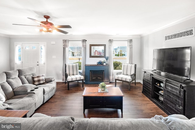 living area featuring a fireplace, crown molding, baseboards, and wood finished floors