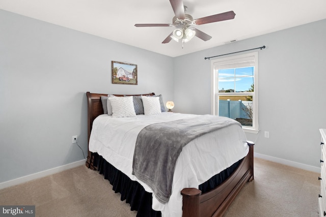 bedroom featuring a ceiling fan, visible vents, baseboards, and light carpet