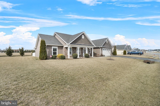 view of front facade with a front yard, a garage, and stone siding