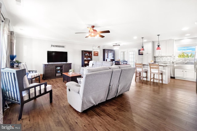 living area with ceiling fan, visible vents, dark wood-style floors, and crown molding