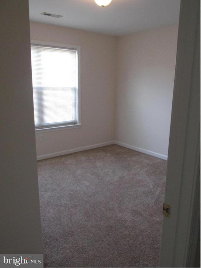 unfurnished room with visible vents, carpet floors, and baseboards