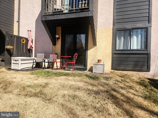 doorway to property with stucco siding and a balcony