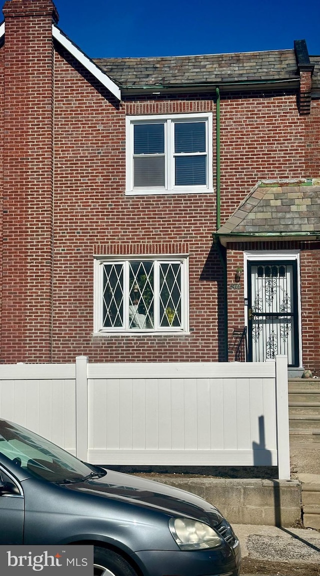 view of front facade with a high end roof and brick siding