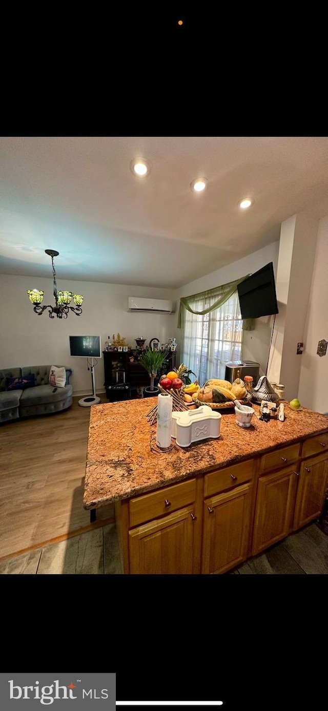 kitchen featuring recessed lighting, light wood-type flooring, light stone counters, and an AC wall unit