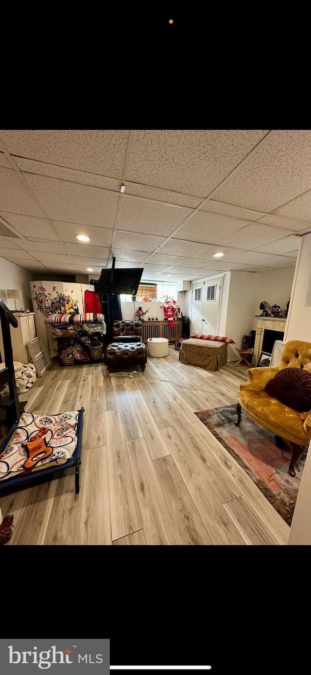 recreation room with a drop ceiling and wood finished floors