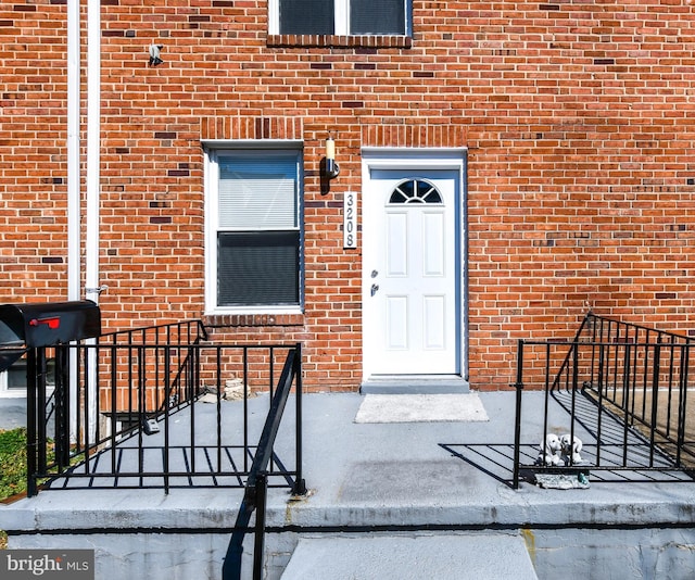 entrance to property featuring brick siding