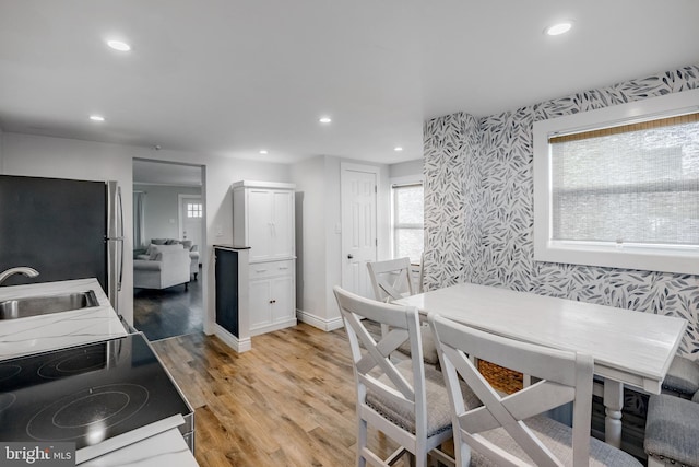 interior space featuring light wood finished floors, recessed lighting, wallpapered walls, and baseboards