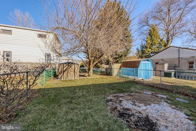 view of yard featuring an outbuilding, a storage unit, and a fenced backyard