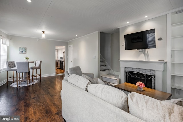 living room with baseboards, built in features, stairs, a fireplace, and wood finished floors