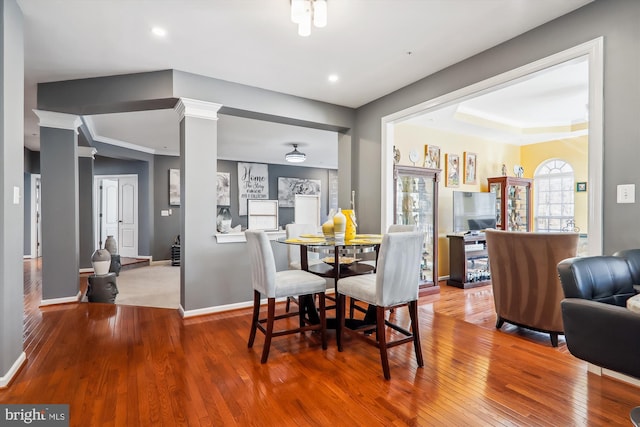 dining area with baseboards, ornamental molding, recessed lighting, hardwood / wood-style flooring, and ornate columns