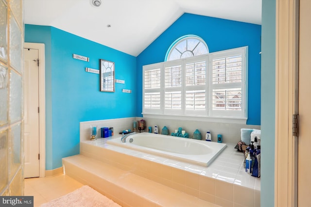 full bathroom with a healthy amount of sunlight, a bath, and vaulted ceiling