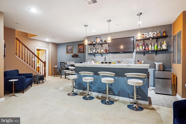 bar with visible vents, stairs, light carpet, wet bar, and freestanding refrigerator