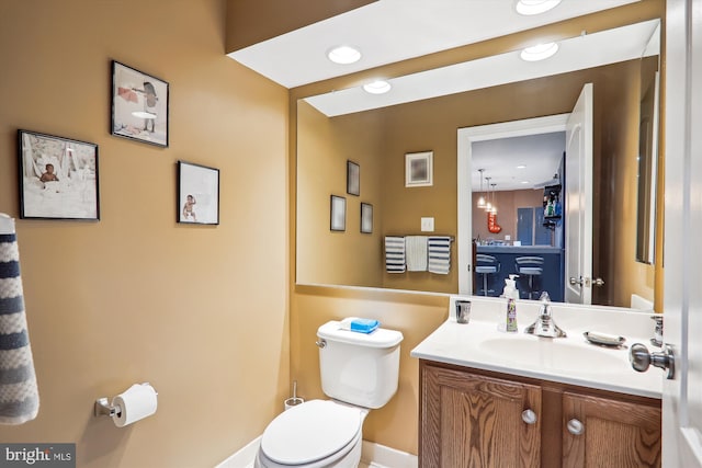 bathroom with vanity, toilet, and recessed lighting