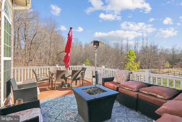 deck with an outdoor living space with a fire pit and outdoor dining area