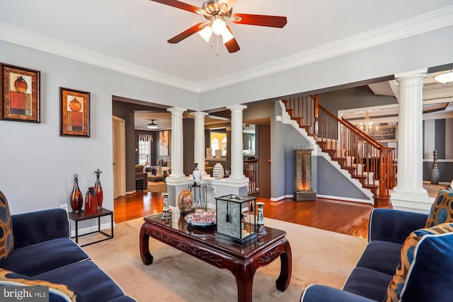 living room featuring decorative columns, wood finished floors, and stairway