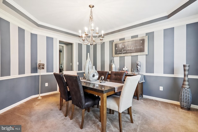 dining area featuring a notable chandelier, baseboards, carpet, and ornamental molding