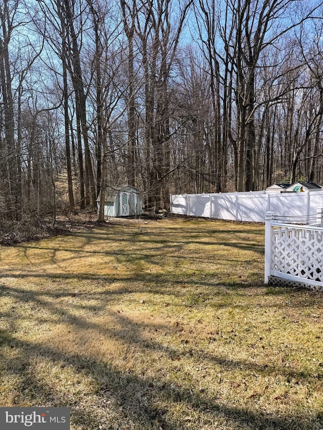 view of yard with an outbuilding, a storage shed, and fence