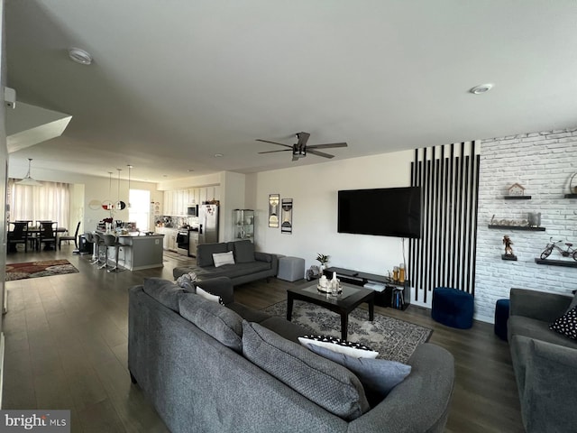 living area with dark wood-type flooring and a ceiling fan