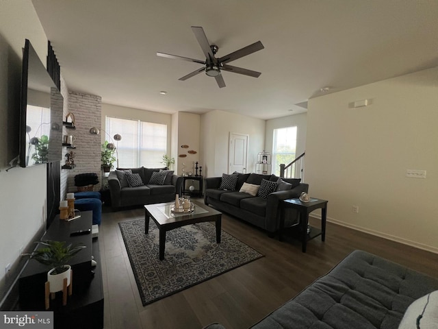 living area with a healthy amount of sunlight, a ceiling fan, baseboards, and wood finished floors