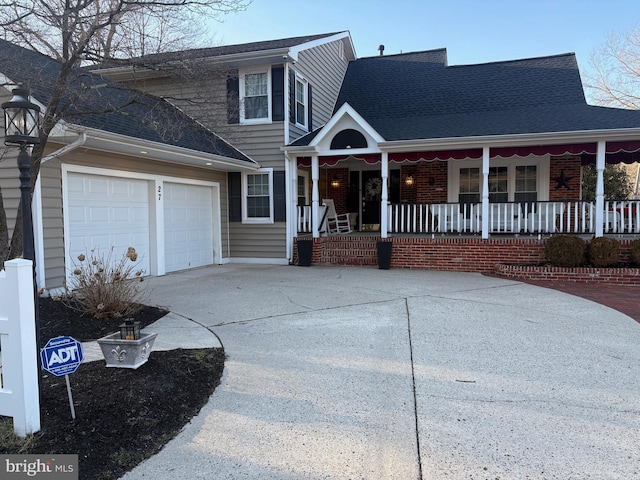 traditional-style house featuring driveway, a porch, roof with shingles, an attached garage, and brick siding