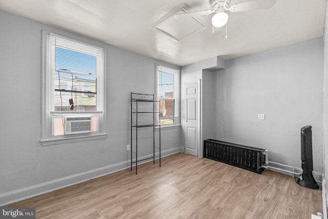 unfurnished bedroom featuring cooling unit, a ceiling fan, baseboards, attic access, and light wood-style floors