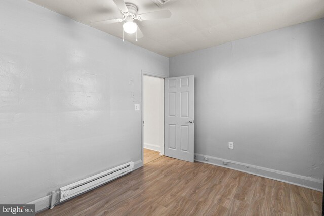 unfurnished room with ceiling fan, wood finished floors, baseboards, and a baseboard radiator