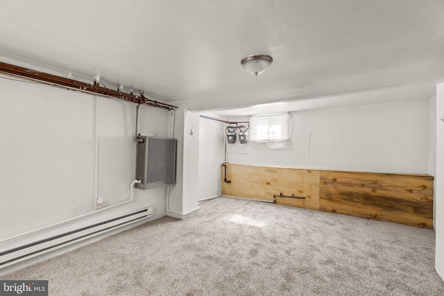 basement with a baseboard heating unit and carpet floors