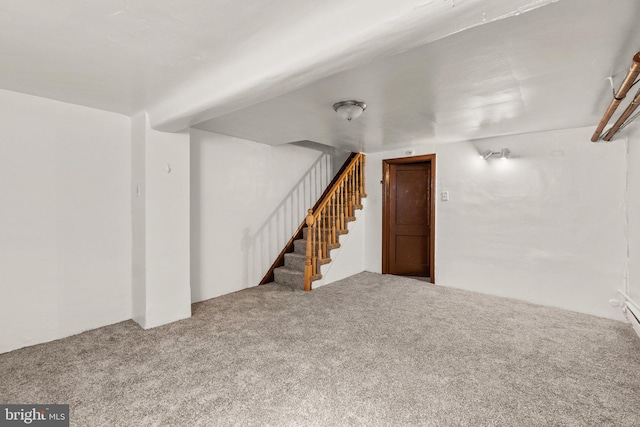 below grade area featuring stairway and carpet