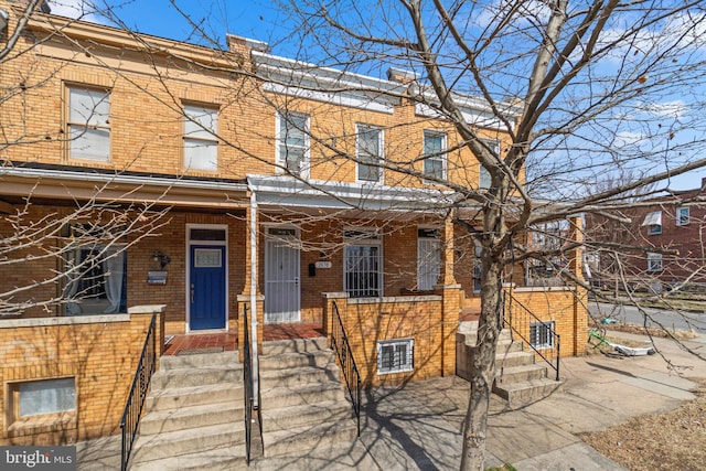 multi unit property featuring brick siding and a porch