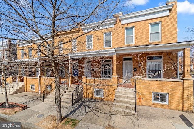 view of front of house featuring brick siding and covered porch