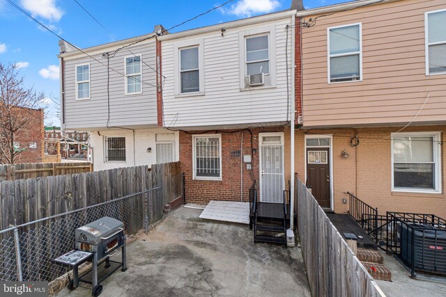 view of front of house with entry steps, central AC, fence, cooling unit, and brick siding