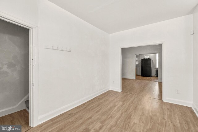 unfurnished room with baseboards and light wood finished floors