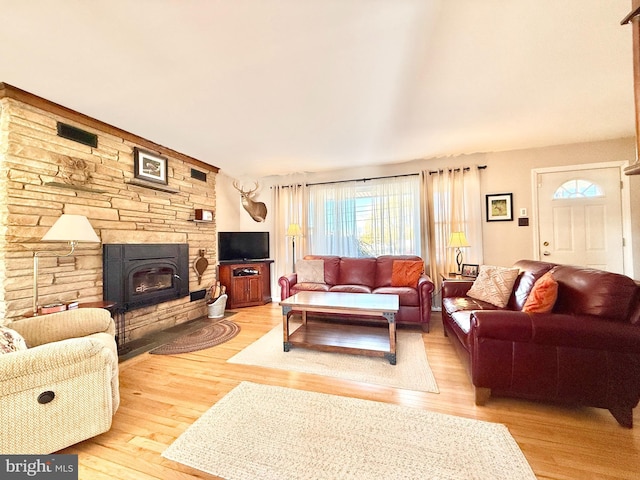 living room with visible vents, a fireplace, and light wood-style floors