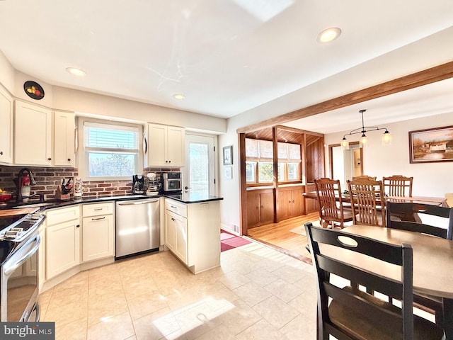 kitchen featuring dark countertops, plenty of natural light, tasteful backsplash, and appliances with stainless steel finishes