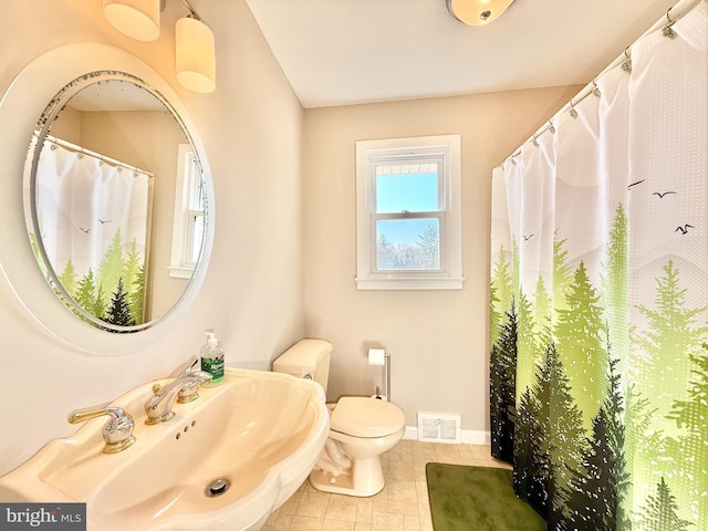 full bath featuring tile patterned flooring, visible vents, baseboards, toilet, and a sink