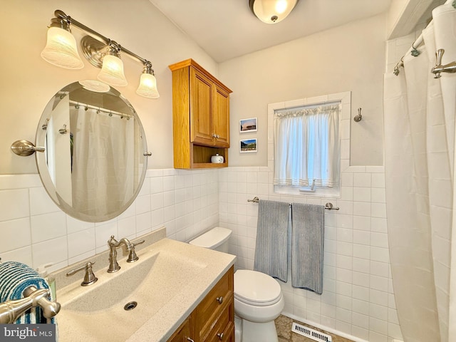 full bathroom featuring visible vents, toilet, a shower with curtain, tile walls, and vanity