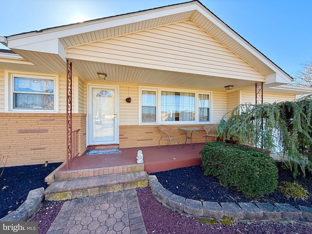 doorway to property featuring brick siding