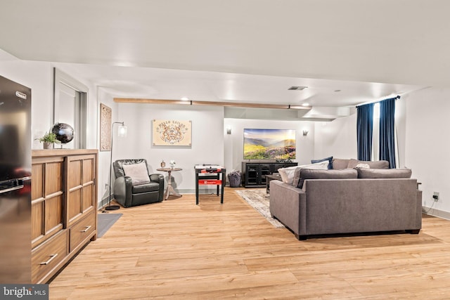 living room featuring light wood-style flooring, baseboards, and visible vents