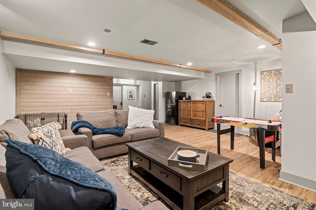 living room featuring recessed lighting, light wood-type flooring, visible vents, and beamed ceiling