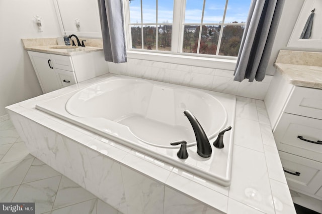 bathroom featuring a garden tub, marble finish floor, and vanity