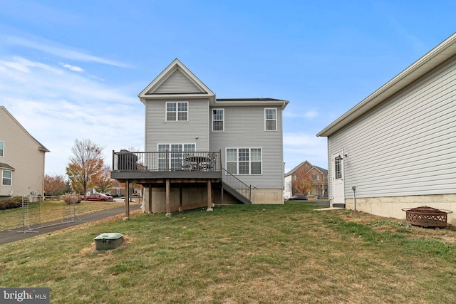 rear view of property with a deck, stairway, and a yard