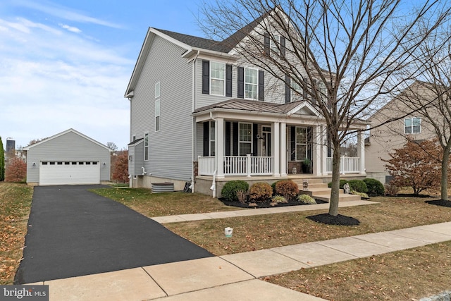 view of front of home featuring a porch, a detached garage, and an outdoor structure