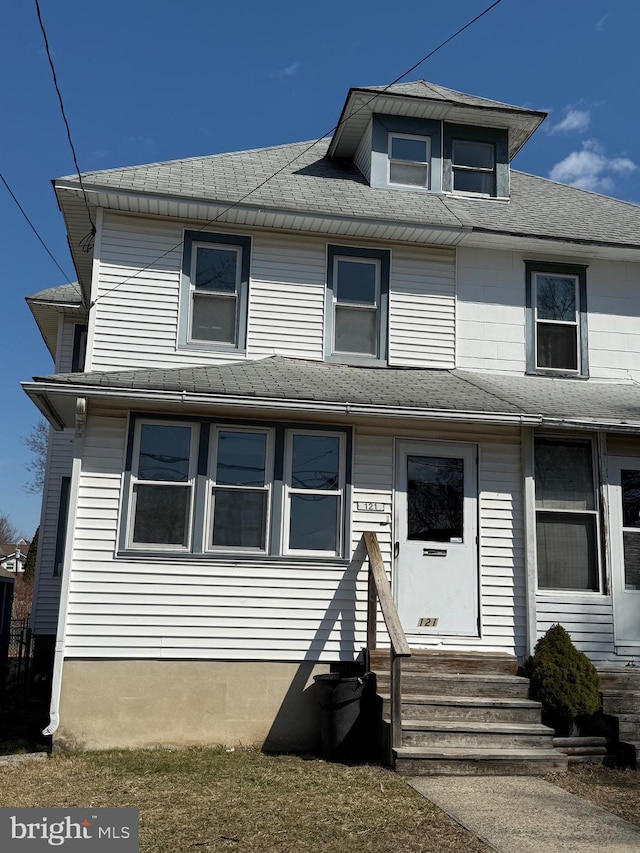 view of front facade with entry steps and a shingled roof