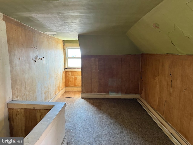 additional living space with lofted ceiling, wooden walls, and carpet