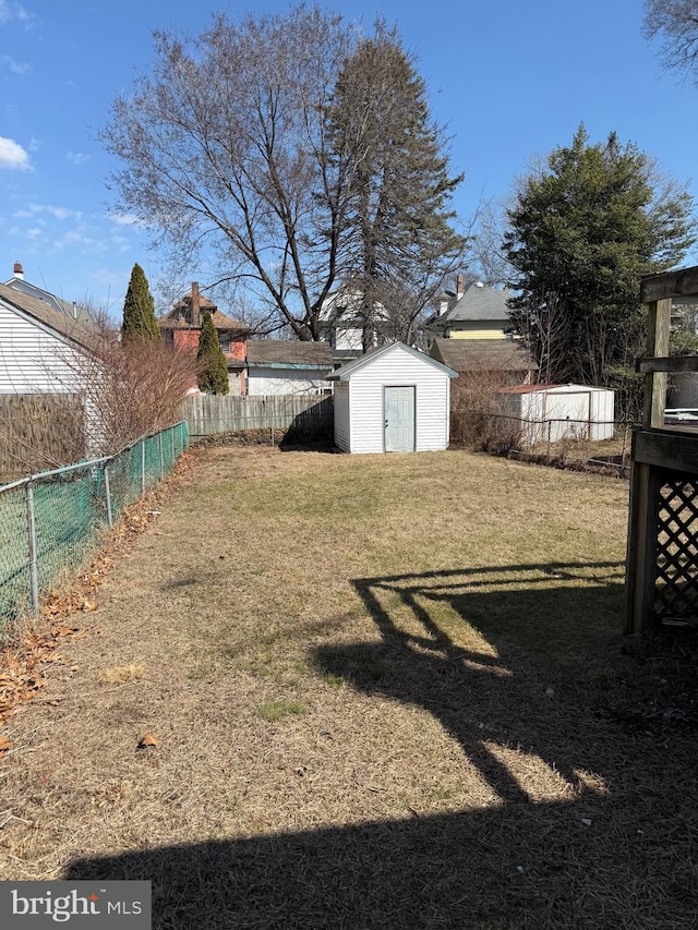 view of yard with an outdoor structure, a storage unit, and a fenced backyard